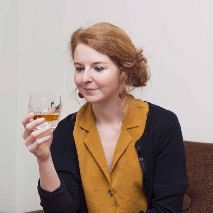 Person studerer glass med whisky