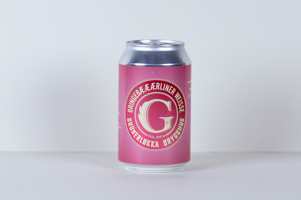 Pink can with a circular cream colored logo on the front standing upright on a white surface against a light gray background