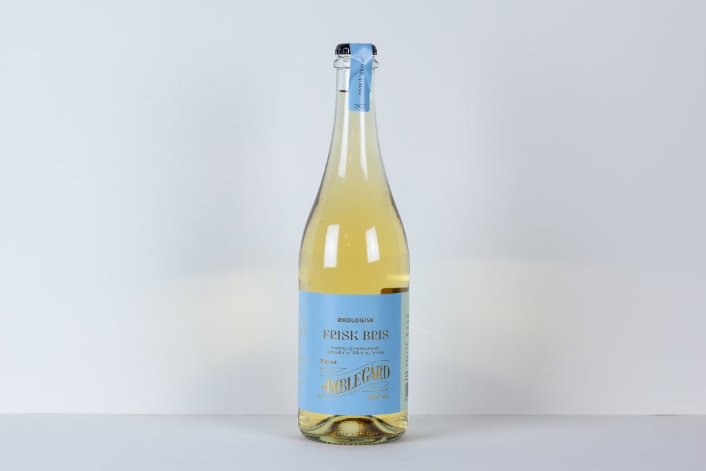 Tall bottle with pale yellow liquid and a blue label centered on a white background label text includes FRISK BRIS