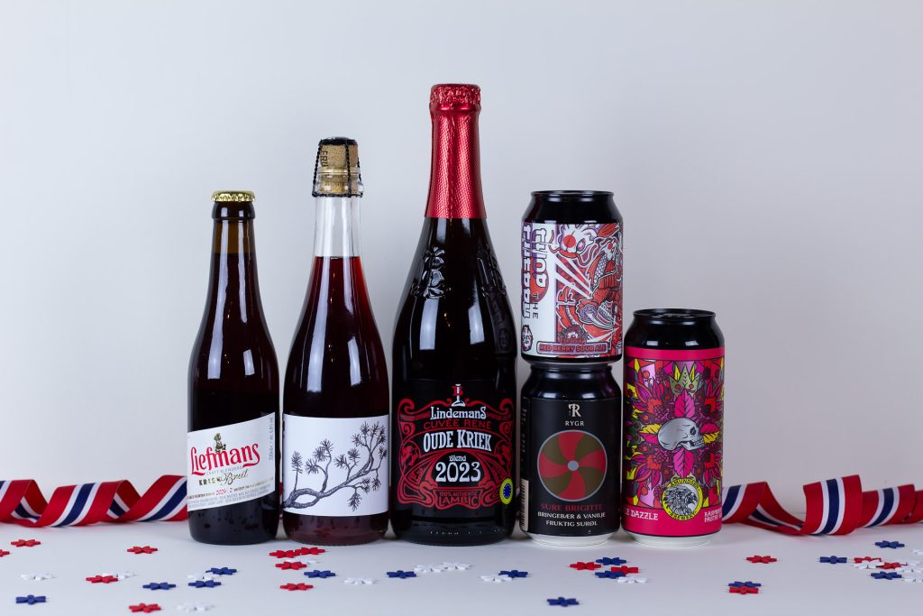 Row of craft beer bottles and a can with colorful labels on a white surface with redwhiteblue ribbon and confetti