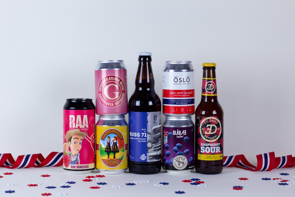 Row of colorful beer cans and bottles on a white table with red white and blue confetti scattered nearby